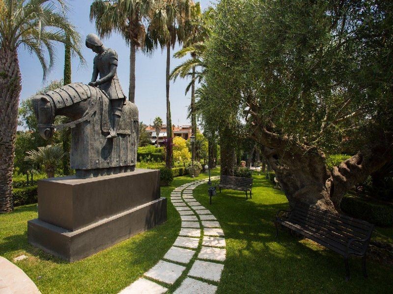 Extensive garden with palm trees and sculptures